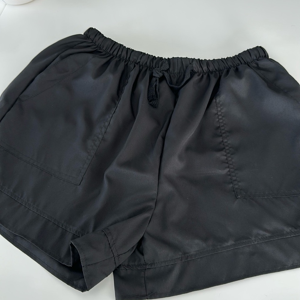 Black Pull on Shorts with tie string to tighten. Side pockets and back pockets.